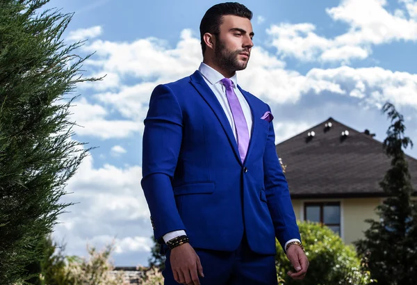 Elegante hombre guapo en traje azul clásico pose al aire libre —  Fotos de Stock