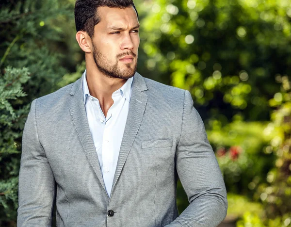 Elegante hombre guapo en chaqueta clásica posa al aire libre —  Fotos de Stock