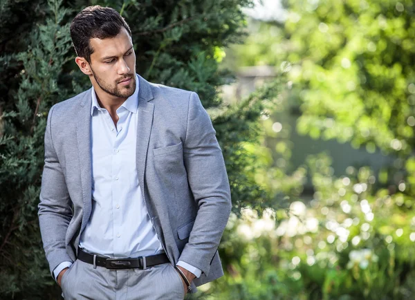Elegant stilig man i klassisk jacka poserar utomhus — Stockfoto