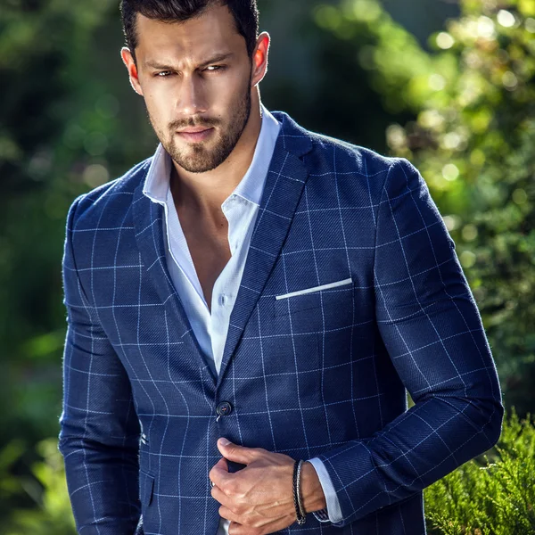 Elegante hombre guapo en chaqueta clásica posa al aire libre — Foto de Stock