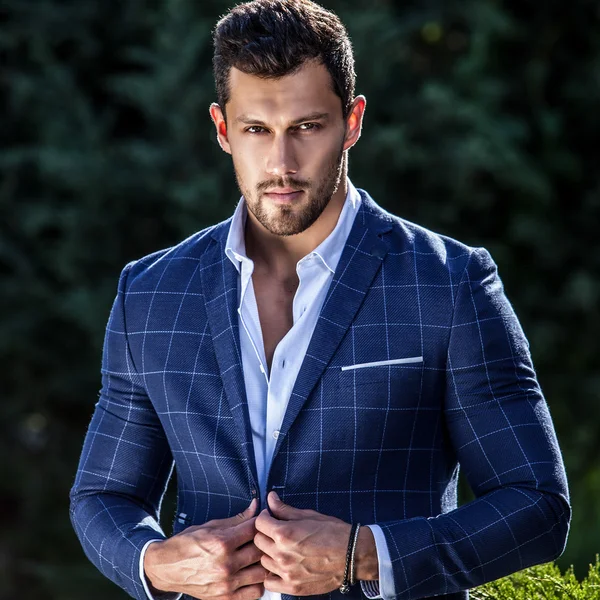 Elegante hombre guapo en chaqueta clásica posa al aire libre — Foto de Stock