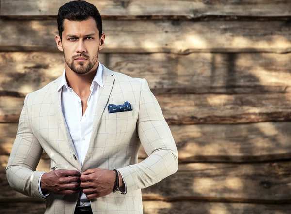 Retrato de joven hermoso hombre de moda contra la pared de madera — Foto de Stock