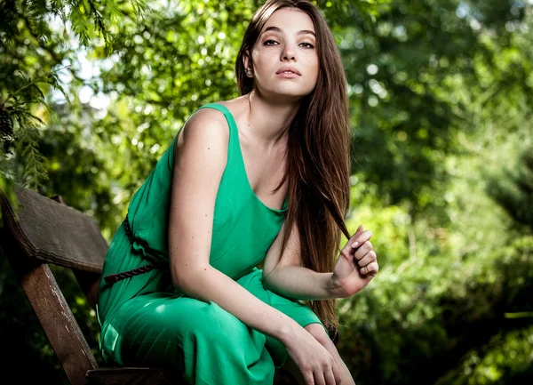 Outdoors portrait of beautiful emotional young woman in green dress — Stock Photo, Image