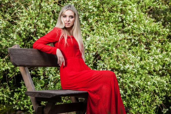 Outdoors portrait of beautiful young blond woman in long red dress — Stock Photo, Image