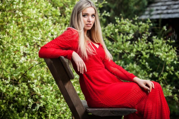 Retrato al aire libre de la hermosa mujer rubia joven en vestido largo rojo — Foto de Stock