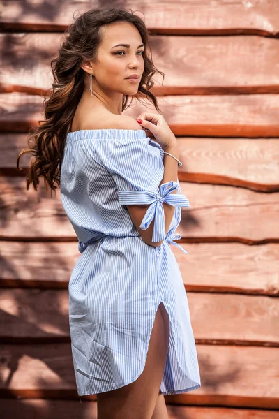 Giovane sensuale & bellezza ragazza in abito blu posa contro grunge sfondo in legno — Foto Stock