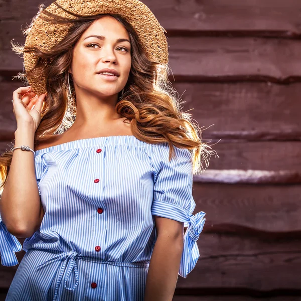 Portrait of beautiful young woman in classic hat against old wooden wall — Stock Photo, Image