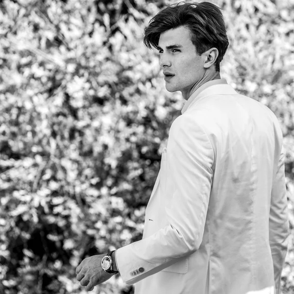 Elegante bonito homem no branco traje pose ao ar livre — Fotografia de Stock