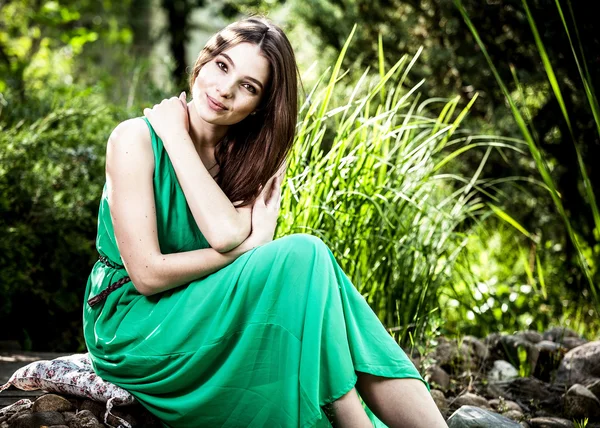 Outdoors portrait of beautiful emotional young woman in green dress — Stock Photo, Image