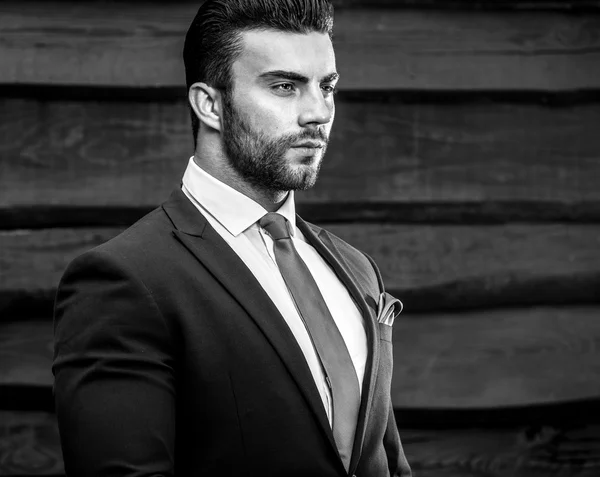 Portrait of young beautiful fashionable man against wooden wall — Stock Photo, Image