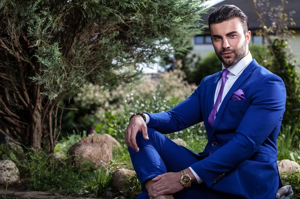 Elegante hombre guapo en traje clásico pose al aire libre . — Foto de Stock