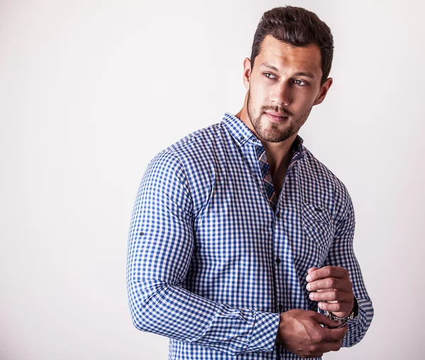 Elegante joven hombre guapo en camisa azul con estilo. Estudio retrato de moda — Foto de Stock