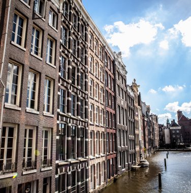 Amsterdam, Hollanda - 6 Ağustos 2016: Amsterdam şehir merkezine yakın çekim ünlü binaların. Genel peyzaj görünümü geleneksel Hollanda Mimarlık ve şehir sokakları. Amsterdam - Hollanda.