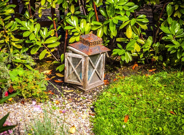 Antigua lámpara con mantequilla en un jardín . — Foto de Stock