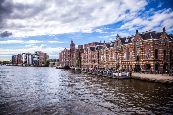 Amsterdam, Nederländerna - 14 augusti 2016: Berömda industriella byggnader av Amsterdam city närbild. De allmänna liggande vy av staden byggnad och traditionell holländsk arkitektur. Amsterdam - Nederländerna. — Stockfoto