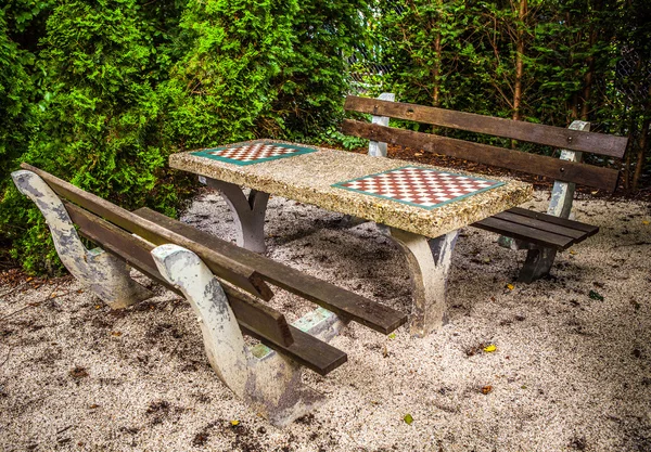 Panchine in parco con tavolo per una partita a scacchi . — Foto Stock