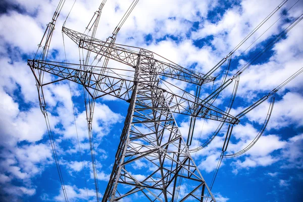 Pilón de transmisión de electricidad contra el cielo azul al atardecer . —  Fotos de Stock