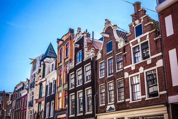 AMSTERDAM, NETHERLANDS - AUGUST 15, 2016: Famous buildings of Amsterdam city centre close-up. General landscape view of city streets and traditional Dutch architecture. Amsterdam - Netherlands. — Stock Photo, Image