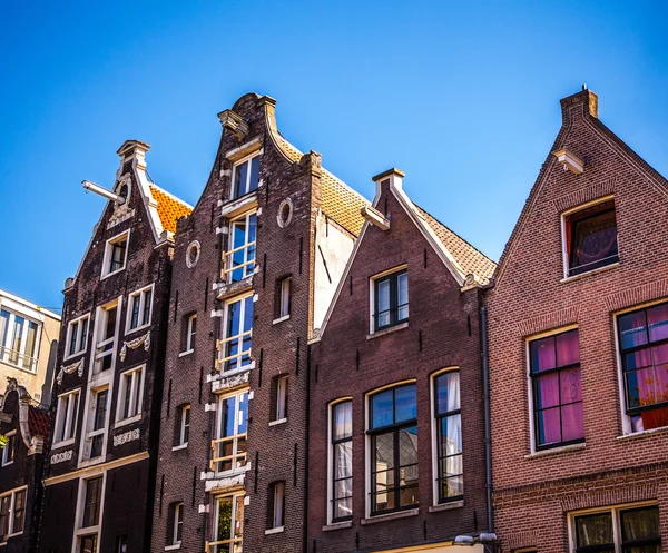 AMSTERDAM, NETHERLANDS - AUGUST 15, 2016: Famous buildings of Amsterdam city centre close-up. General landscape view of city streets and traditional Dutch architecture. Amsterdam - Netherlands. — Stock Photo, Image