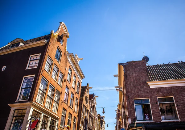 AMSTERDAM, NETHERLANDS - AUGUST 15, 2016: Famous buildings of Amsterdam city centre close-up. General landscape view of city streets and traditional Dutch architecture. Amsterdam - Netherlands. — Stock Photo, Image