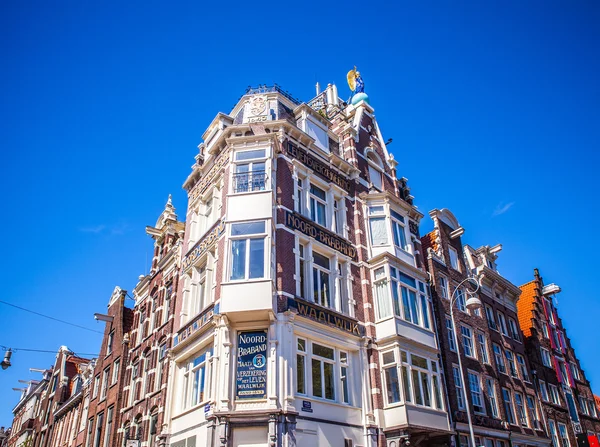 AMSTERDAM, NETHERLANDS - AUGUST 15, 2016: Famous buildings of Amsterdam city centre close-up. General landscape view of city streets and traditional Dutch architecture. Amsterdam - Netherlands. — Stock Photo, Image