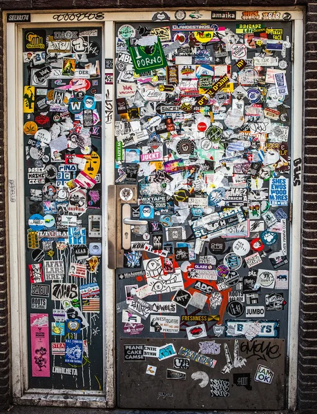 AMSTERDAM, NETHERLANDS - AUGUST 15, 2016: Street wall covered numerous multicolored stickers on August 15 in Amsterdam, The Netherlands. — Stock Photo, Image