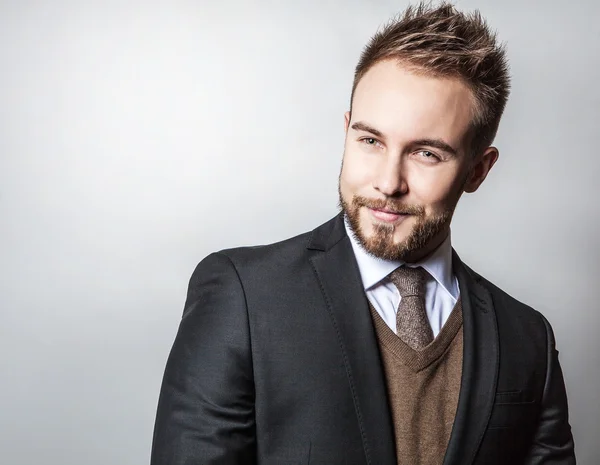 Eleganter und positiver junger gutaussehender Mann im Kostüm. Modeporträt im Studio. — Stockfoto