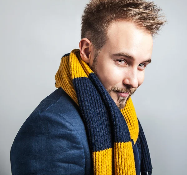 Elegante y positivo joven guapo hombre en bufanda de colores. Estudio retrato de moda . — Foto de Stock