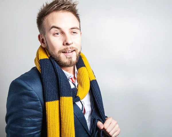 Eleganter und positiver junger gutaussehender Mann in buntem Schal. Modeporträt im Studio. — Stockfoto