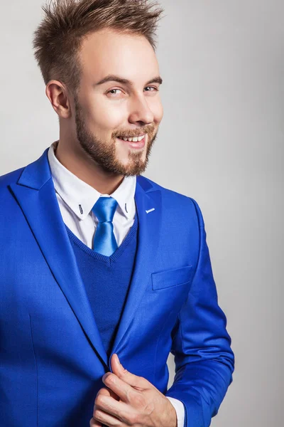 Elegante e amichevole giovane bell'uomo in costume alla moda. Studio uomo ritratto . — Foto Stock