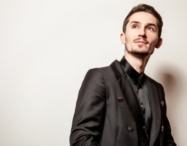 Siyah kostümlü zarif genç yakışıklı adam. Studio moda portre.