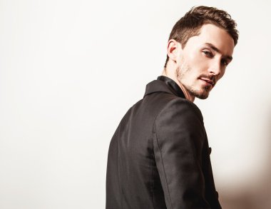 Siyah kostümlü zarif genç yakışıklı adam. Studio moda portre.
