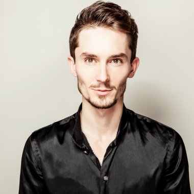 Siyah ipek gömlekli zarif genç yakışıklı adam. Studio moda portre.