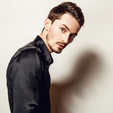 Siyah ipek gömlekli zarif genç yakışıklı adam. Studio moda portre.