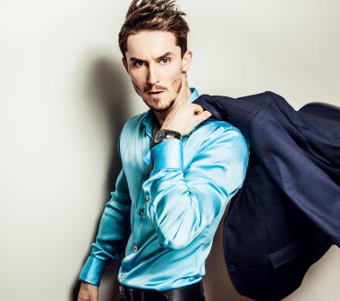 Mavi ipek gömlekli zarif genç yakışıklı adam. Studio moda portre.