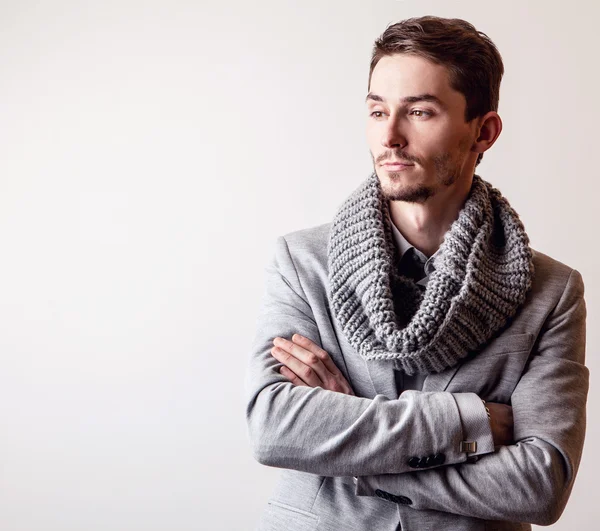 Eleganter junger gutaussehender Mann im grauen Kostüm. Modeporträt im Studio. — Stockfoto
