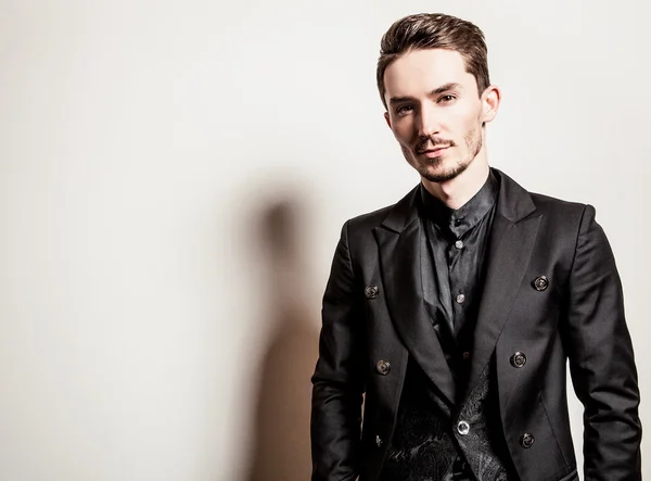 Elegante jovem bonitão vestido de preto. Estúdio retrato de moda . — Fotografia de Stock