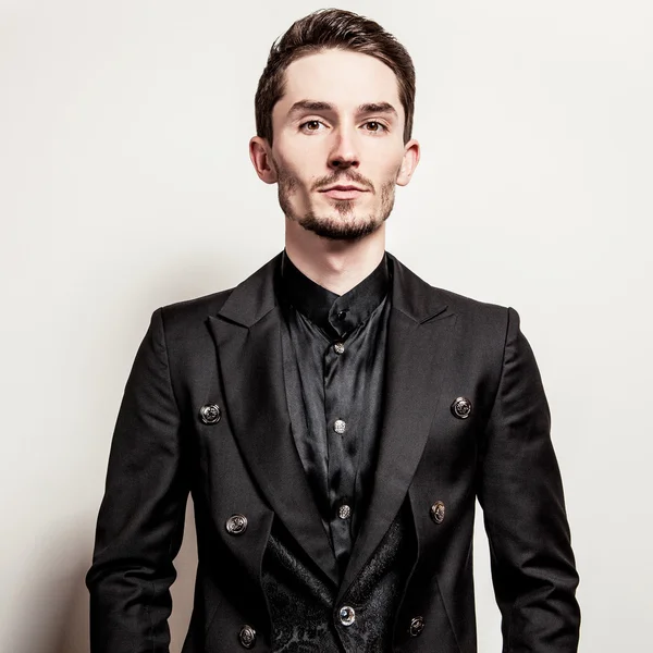 Elegante jovem bonitão vestido de preto. Estúdio retrato de moda . — Fotografia de Stock