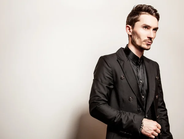 Elegante jonge knappe man in zwart kostuum. Studio mode portret. — Stockfoto