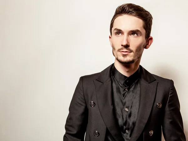 Elegante jovem bonitão vestido de preto. Estúdio retrato de moda . — Fotografia de Stock