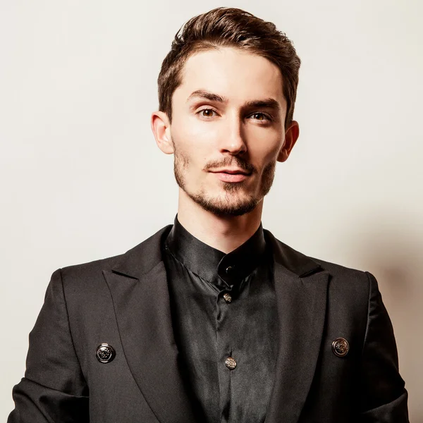 Elegante jovem bonitão vestido de preto. Estúdio retrato de moda . — Fotografia de Stock