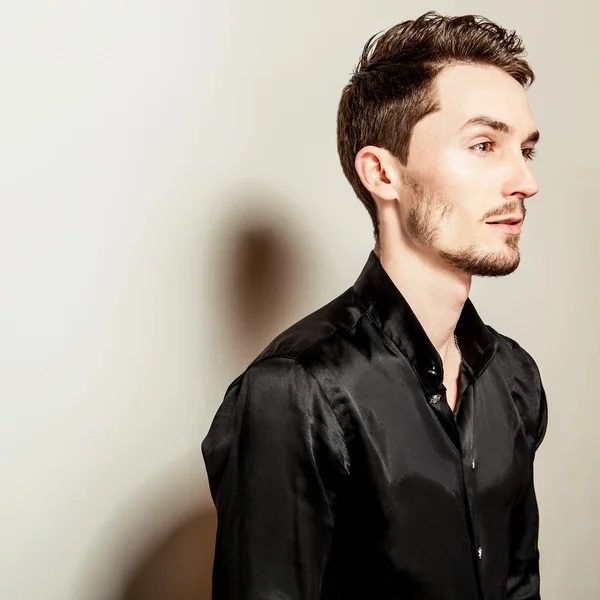 Elegant young handsome man in black silk shirt. Studio fashion portrait. — Stock Photo, Image