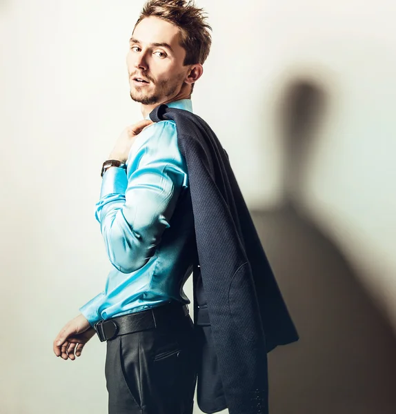 Elegante jonge knappe man in blauwe zijde shirt. Studio mode portret. — Stockfoto