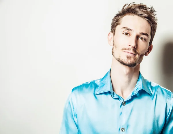 Elégant jeune homme élégant en chemise de soie bleue. Studio portrait de mode . — Photo