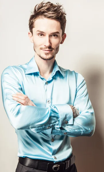 Elegante jonge knappe man in blauwe zijde shirt. Studio mode portret. — Stockfoto