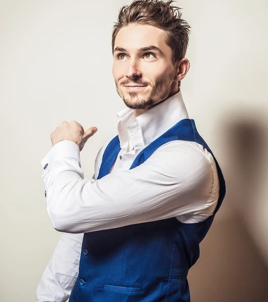 Elegant ung vacker man i vit skjorta & vest. Studio mode porträtt. — Stockfoto