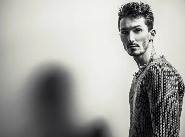 Черно-белый студийный портрет молодого красивого мужчины в вязаном свитере. Крупный план . — стоковое фото