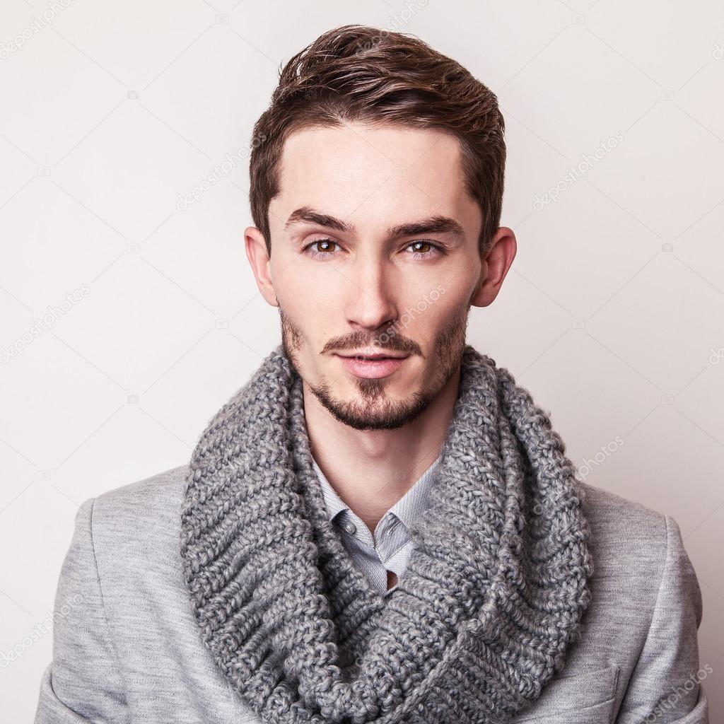 Elegant young handsome man in grey costume. Studio fashion portrait.