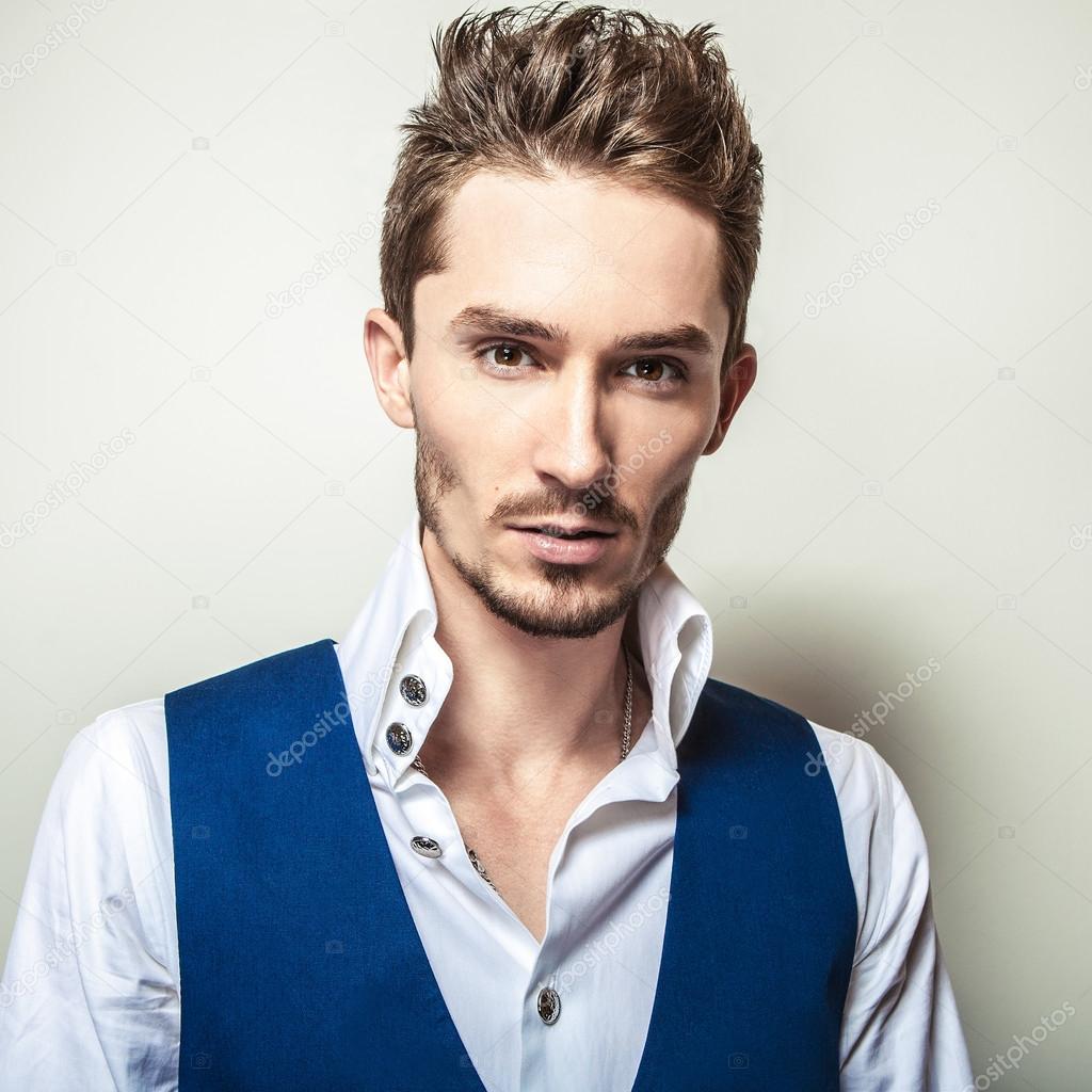 Elegant young handsome man in white shirt & vest. Studio fashion portrait.