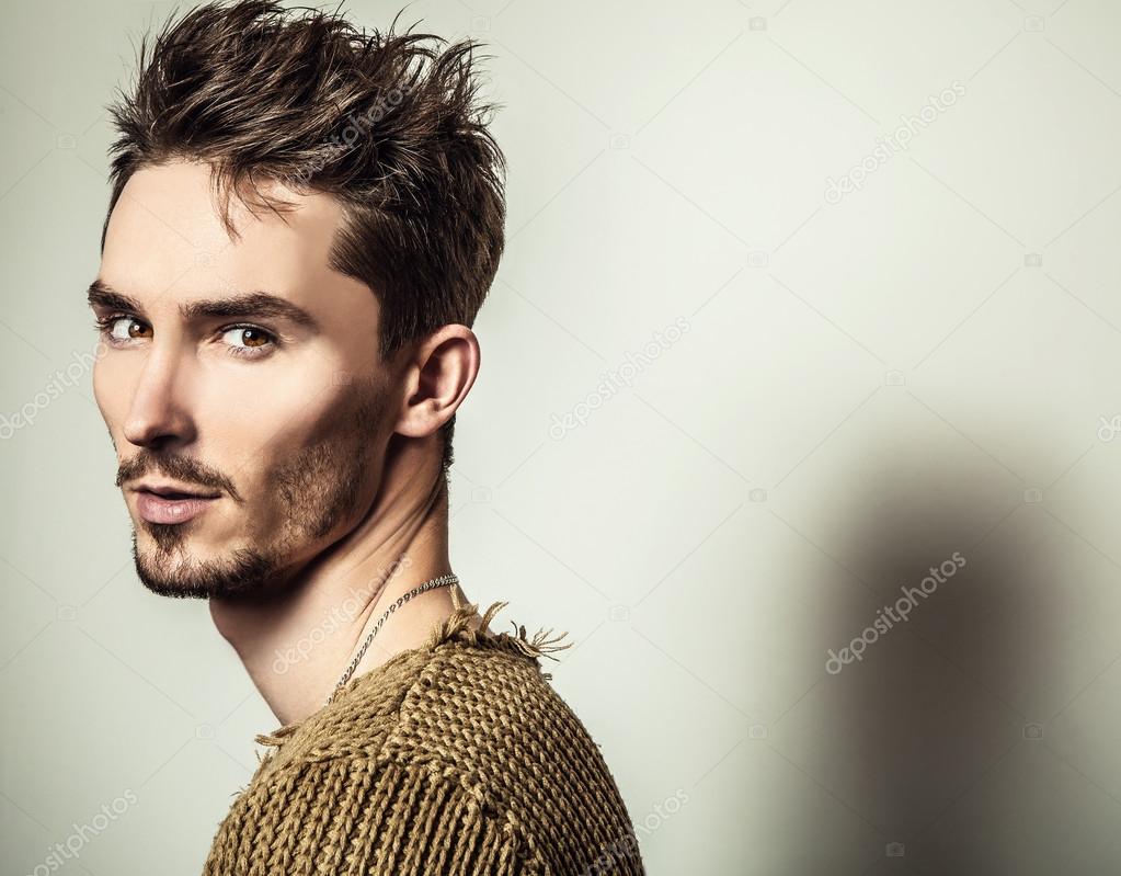 Studio portrait of young handsome man in knitted sweater. Close-up photo.